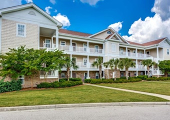 large 3 story apartment building with grass lawn infront, myrtle beach pet friendly vacation rental home